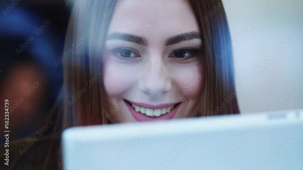 Outside shooting of a happy beautiful woman’s face sitting by the window in a café and using her tablet, smiling brightly. Modern technologies, having fun. Outside shooting of a happy beautiful woman’s face sitting by the window in a café and using her tablet, smiling brightly. Modern technologies, having fun.