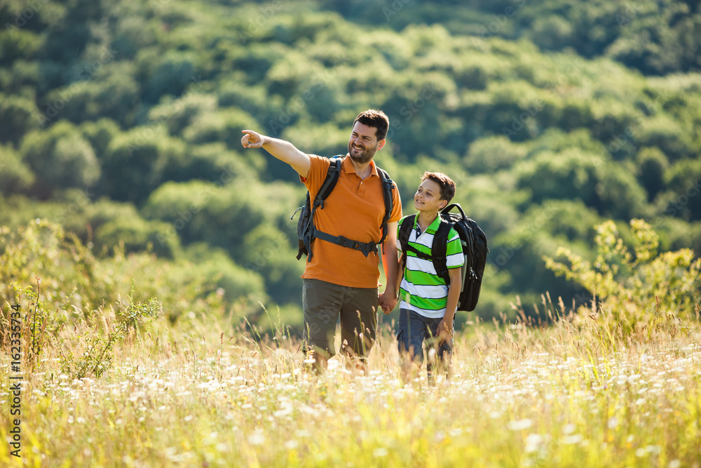 Father and son are hiking in nature in summer. Father and son are hiking in nature in summer.