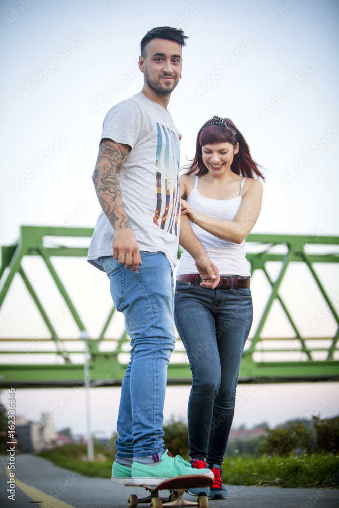 Young man skateboarding, woman bears a helping hand Young man skateboarding, woman bears a helping hand