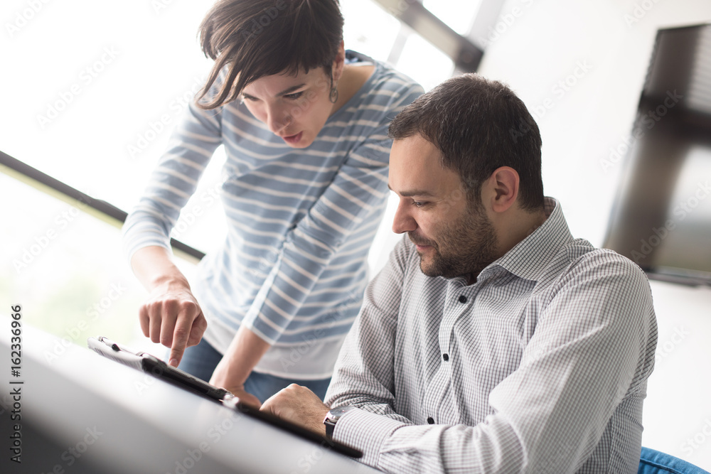 Two Business People Working With Tablet in startup office Two Business People Working With Tablet in startup office