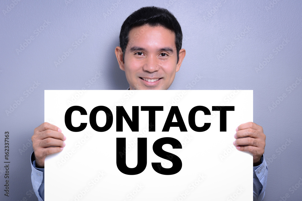 Smiling man showing CONTACT US sign Smiling man showing CONTACT US sign