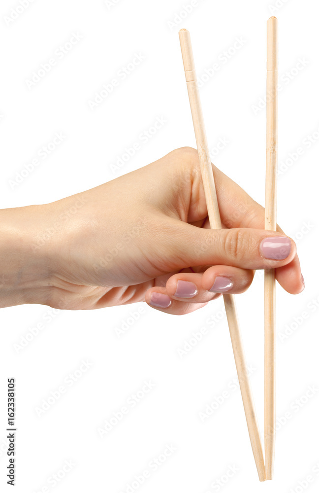 Female hand holds chopsticks on a white background Female hand holds chopsticks on a white background