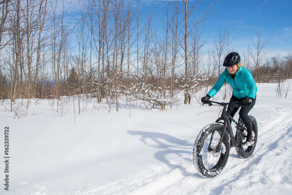 Beautiful woman riding her fat bike in the snow