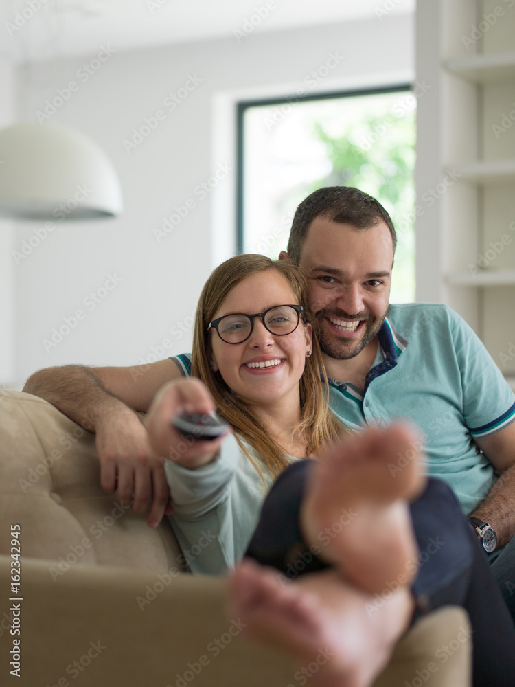 Young couple on the sofa watching television Young couple on the sofa watching television