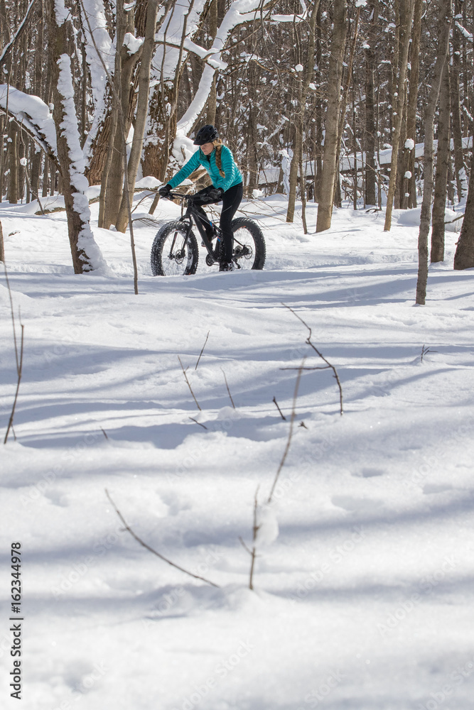 Beautiful woman riding her fat bike in the snow