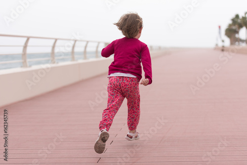 cute little girl on the promenade by the sea