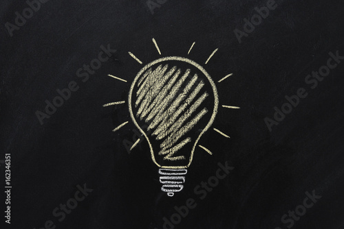 Fotografie close up of yellow electric bulb drawn on black chalkboard