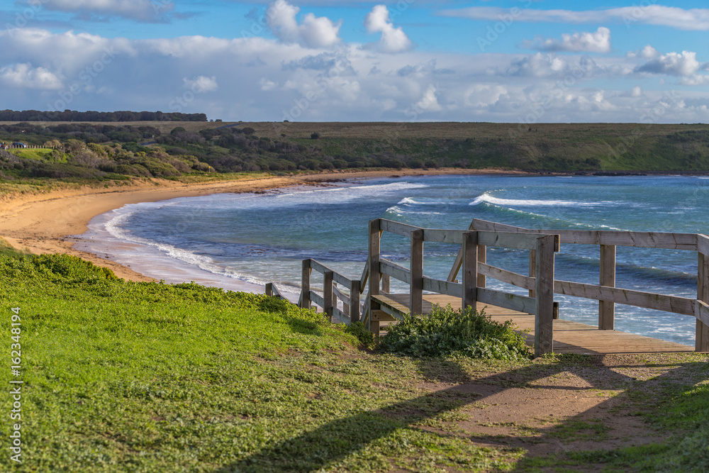 Sunny seaside view with from top of a hill with a wooden staircase on Phillip Island Australia