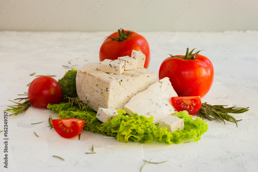 Lettuce leaves, cherry tomatoes, broccoli and tofu on white background.