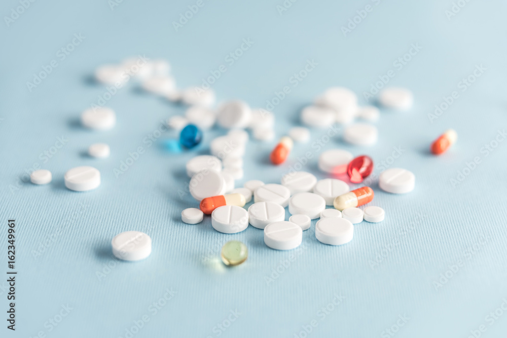 Close up of white tablets and colorful capsules