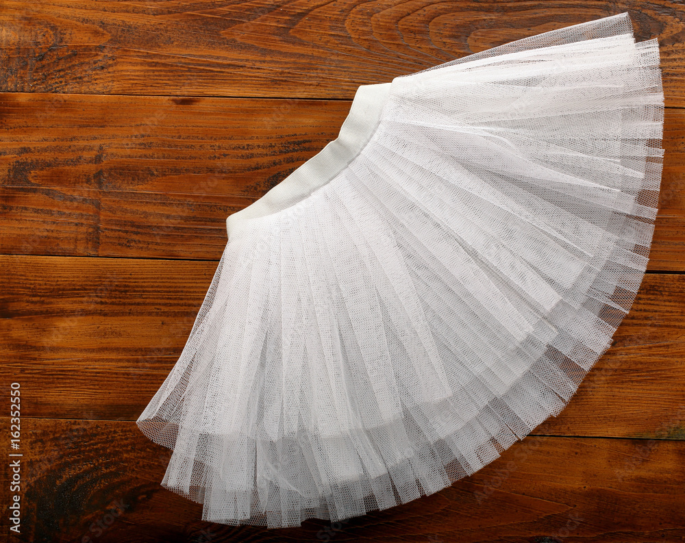White tutu skirt on wooden background with empty space for text - obrazy, fototapety, plakaty 