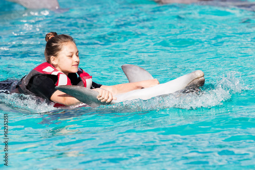 Girl and dolphin swim together