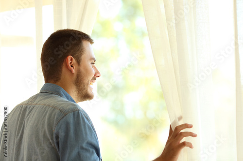 Pensive man looking through a window