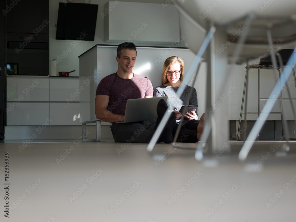 couple using tablet and laptop computers