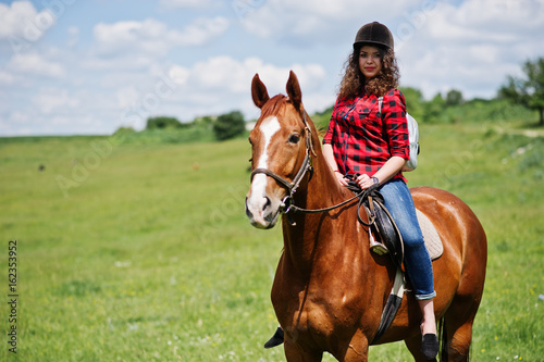 Young pretty girl riding a horse on a field at sunny day. © AS Photo Family