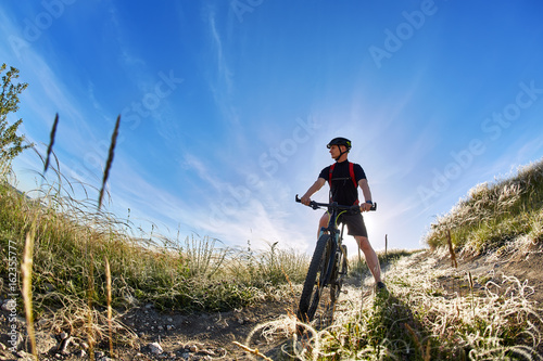 Wide angle of the cyclist with mountain bicyclist against beautiful landscape.