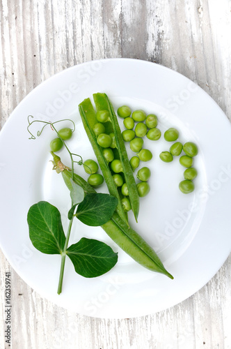 petits pois frais et gousses dans assiette avec feuille