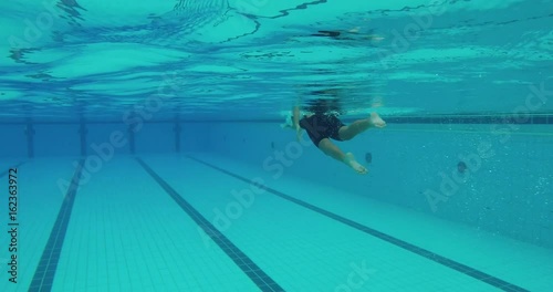 Young asian girl swims freestyle and does tumble turn