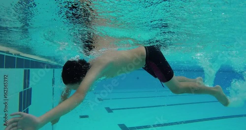 Young asian boy swims freestyle and does tumble turn