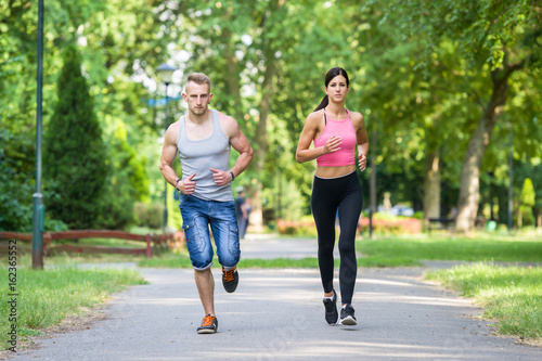 sport woman and man running together in a park in summer © dobok