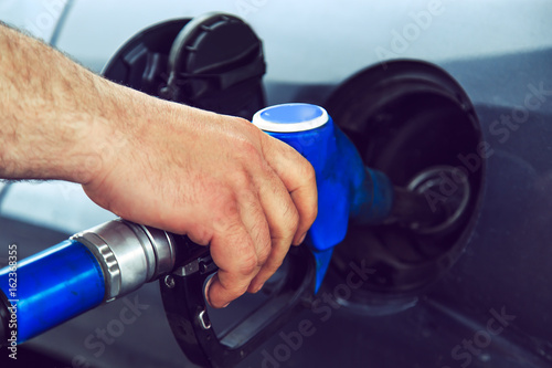 Close-up of a man's hand using a gasoline pump.