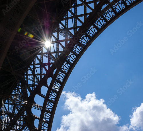 Sun shining through Eiffel Tower. Colorful beams and spots. Paris (France)