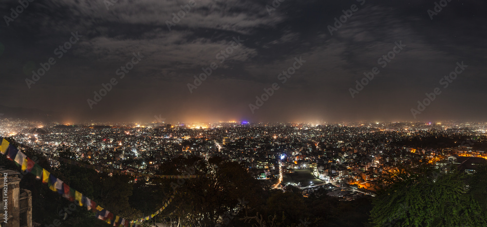 Panoramic view from Svayambunath stupa point of view on the infinite city of Kathmandu in drama night-time lighting.