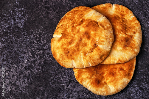 Pita bread on a dark table.