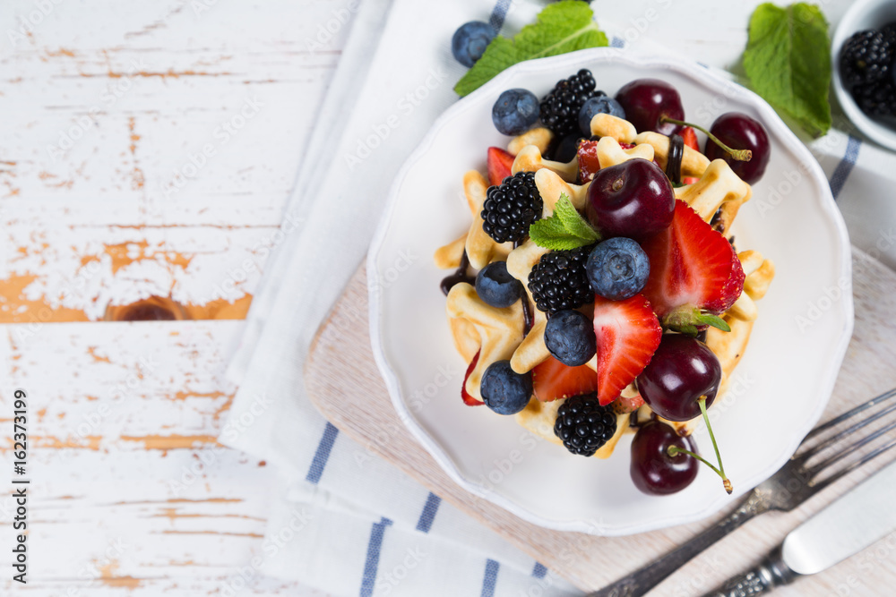 Breakfast - waffles with berries on white plate Breakfast - waffles with berries on white plate