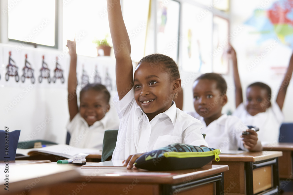 Kids raising hands during a lesson at an elementary school Kids raising hands during a lesson at an elementary school