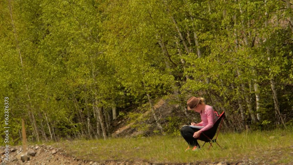 female artist paiting a jungle themed picture with watercolours, outdoors in a nature
female artist paiting a jungle themed picture with watercolours, outdoors in a nature