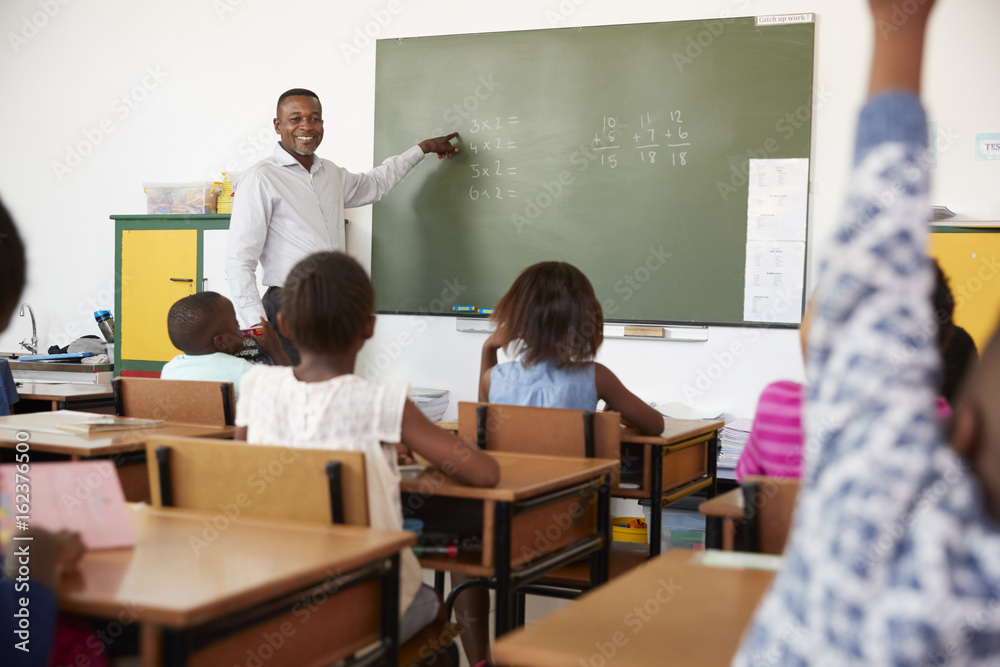 Teacher using chalkboard in a lesson at an elementary school Teacher using chalkboard in a lesson at an elementary school
