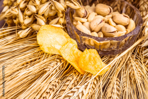 Pistachio nuts, peanuts and potato chips for beer photo