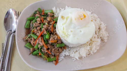 Stir fried Pork with chili and basil with steamed rice and over hard fried egg - Thai food.