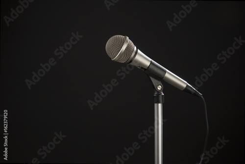 Microphone on a stand seen from the side on a black background