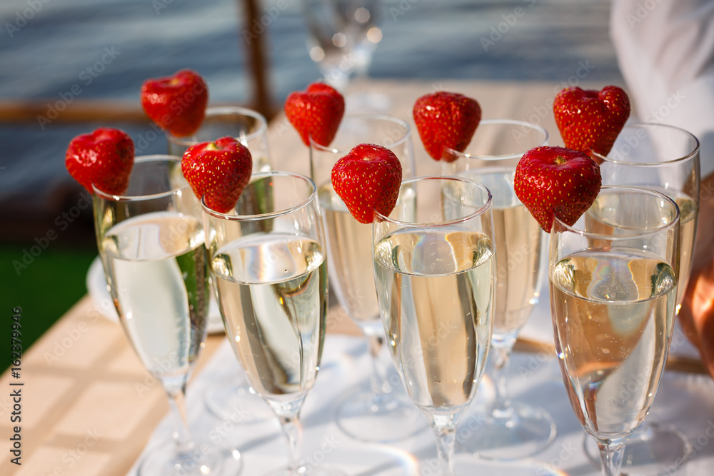 Obraz premium Waiter Standing With Champagne Glasses Next To Arranged Wedding Table