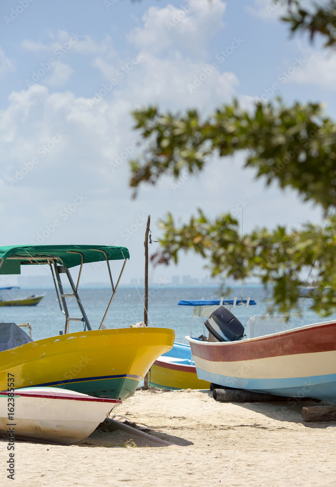 Colorful boats on the beach. Turquoise water of the Caribbean sea in the background. White sand beach.