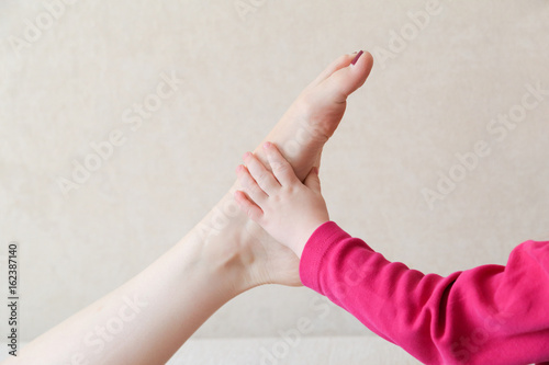 The child s hand touches the female leg.