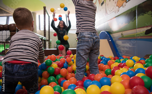 Young mom with her kids in a children's playroom photo