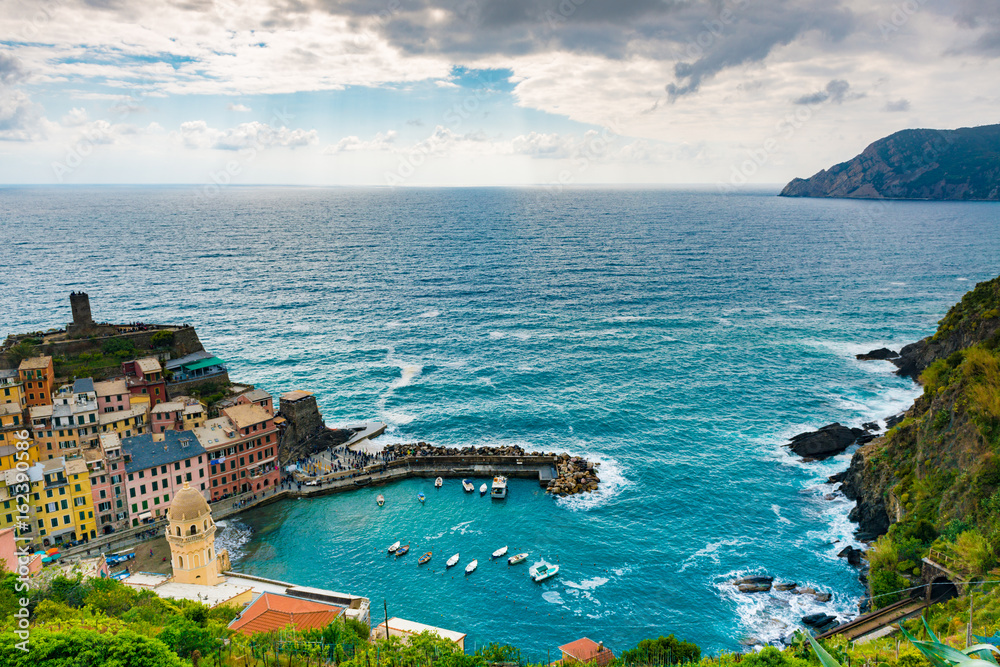 view of famous travel landmark destination Vernazza, a small mediterranean old sea town with harbour,coast and castle, Cinque terre National Park, Liguria, Italy. Summer daylight with clouds