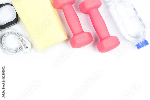 sport, healthy lifestyle and objects concept - close up of dumbbells, fitness tracker, earphones and water bottle over white background © dashu83