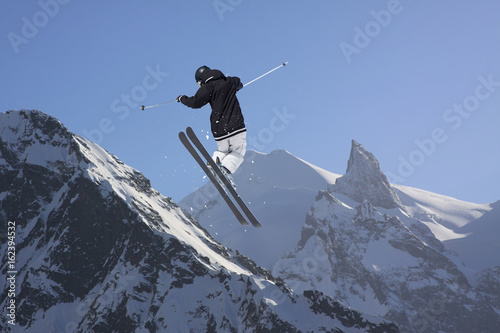Flying skier in the mountains. Extreme freeride sport.