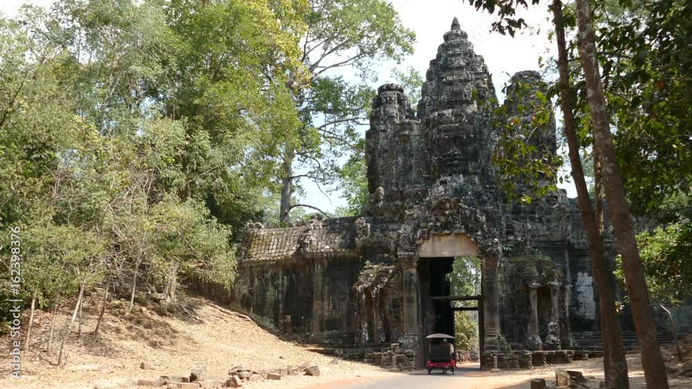 Tuk Tuk drives through one of the gates at Angkor Wat Cambodia Tuk Tuk drives through one of the gates at Angkor Wat Cambodia
