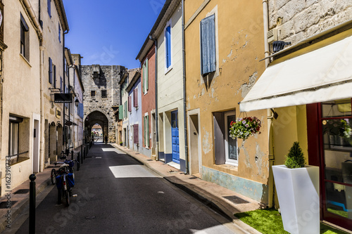Narrow street with colorful houses and bicycle at Aigues-Mortes southern France