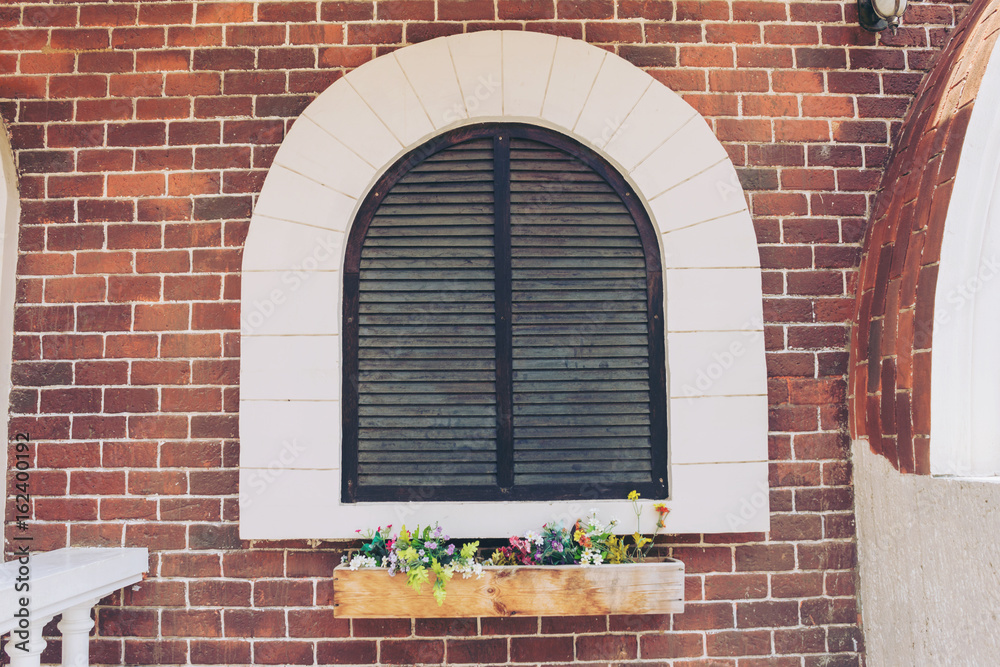 Old arched antique window on a brown wall, the texture of the building facade.