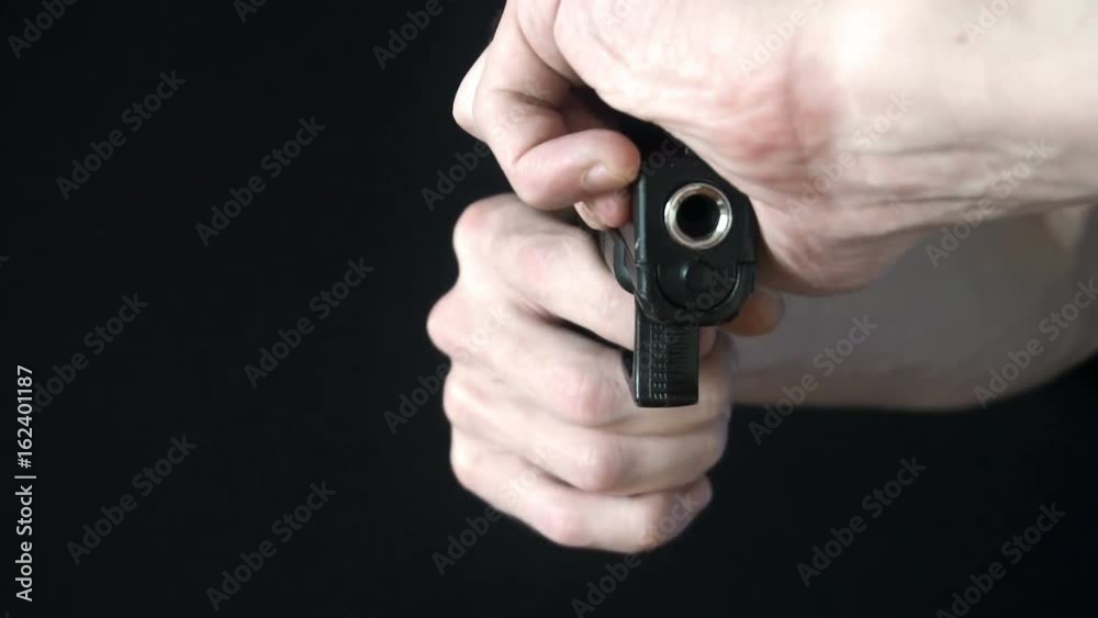 the young man reloads gun black.slow motion the young man reloads gun black.slow motion