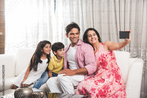 Canvas Print Family time - Indian family taking selfie picture, wife clicking selfie with sma