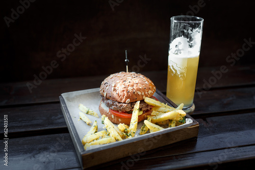 Fast food set: Hamburger, beer and fries. Background old wood photo