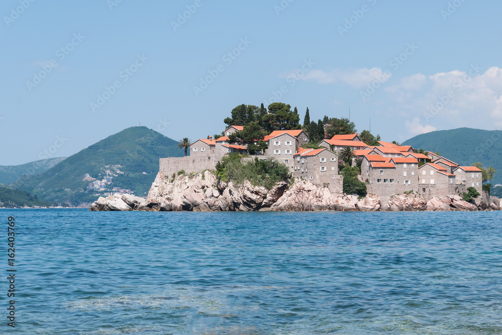 A view of the Sveti Stefan island from the sea on a summer day, Montenegro