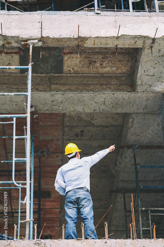 Engineer with blueprint in building construction site